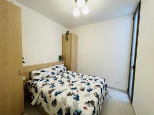 ein Schlafzimmer mit einem Bett mit einer Bettdecke darauf in der Unterkunft NICE CENTRIC APARTMENT in Vilanova i la Geltrú