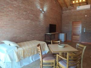 a room with a bed and a table with chairs at Colina del Valle in Mina Clavero