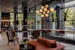 a lobby with a bar and chairs and windows at Radisson RED Oslo Okern in Oslo