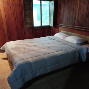 a bedroom with a large bed with two pillows at Pochotel Natural in Turrialba