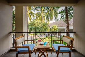 达曼Silver Waves Resort & Spa - Daman的带桌椅的阳台，可欣赏美景