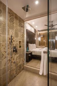 达曼Silver Waves Resort & Spa - Daman的带淋浴的浴室和房间里的一张床