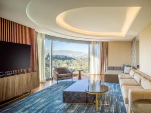 a living room with a couch and a tv at Grand Fiesta Americana Chapultepec in Mexico City