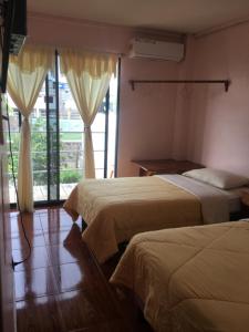 um quarto de hotel com duas camas e uma varanda em Hostal Nathaly em Puerto Baquerizo Moreno