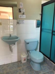 uma casa de banho com um WC azul e um lavatório. em Hostal Nathaly em Puerto Baquerizo Moreno