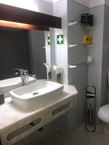 uma casa de banho com um lavatório branco e um espelho. em XAVILLA 8 em Albufeira