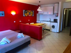 um quarto com duas camas e uma cozinha com paredes vermelhas em XAVILLA 8 em Albufeira
