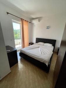 Un dormitorio con una cama y una ventana grande. en Bora Lindi Ulcinj apartments, en Ulcinj