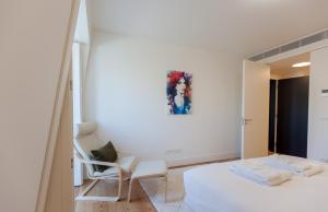 um quarto com uma cama branca e um espelho em FLH Praça Comércio Artistic Flat with Balcony em Lisboa