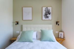 1 cama con 2 almohadas y 2 cuadros en la pared en Veiga da Fraga, en Poio