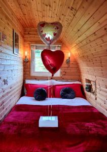 a room with a bed with a heart balloon on it at Forester's Retreat Glamping - Cambrian Mountains View in Aberystwyth