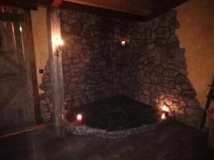 una chimenea de piedra en una habitación con 2 velas en El descanso de Odín ¡Una auténtica posada vikinga! en Mataelpino