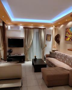 a living room with a couch and a tv at Safe & Cool Apartment in Heraklio Town