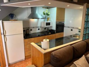 a kitchen with a couch and a white refrigerator at La Marina Urb, Beautiful 4 bedroom House, Alicante, San Fulgencio, Spain in La Marina