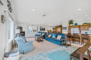 uma sala de estar com sofás azuis e uma cozinha em Gone Coastal em Rockaway Beach