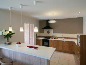 a large kitchen with a white counter top and a island at Gite Moderne de Lourdes in Lourdes