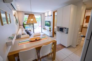 a kitchen and living room with a table and chairs at Porto de Galinhas - Flat com Piscina Exclusiva in Porto De Galinhas