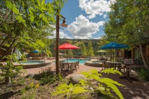 a patio with tables and umbrellas and a swimming pool at 1 Bedroom Mountain Condo In River Run Village With Beautiful Mountain Views And Walking Distance To Ski in Keystone