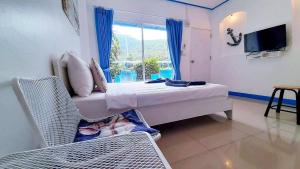 a room with a bed and a television and a window at Blue sky Koh larn Resort in Ko Larn