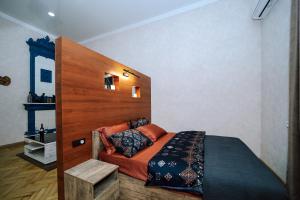 sypialnia z łóżkiem z drewnianym zagłówkiem w obiekcie Apartment Alexandra w mieście Tbilisi City