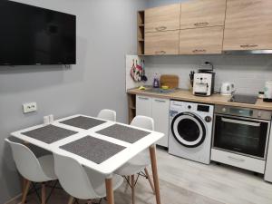 a kitchen with a table and a washing machine at Dark side Inn in Ruse