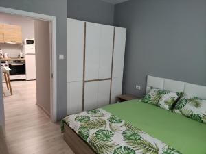 a bedroom with a bed with a green and white comforter at Dark side Inn in Ruse
