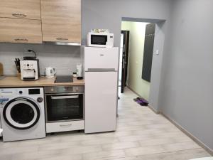 eine Küche mit einem weißen Kühlschrank und einer Mikrowelle in der Unterkunft Dark side Inn in Ruse