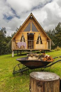 a wheel barrow in front of a small house at Glamping las 4 estaciones in Guatavita