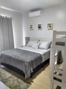 a small bedroom with a bed and a ladder at Cantinho da Vila Hospedagem in Penha