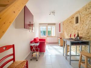 uma sala de estar com uma cadeira vermelha e uma mesa em Snug holiday home in Bergerac with terrace em Bergerac