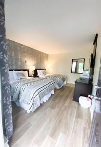 a bedroom with two beds and a television in it at Lincoln Inn Fredericton in Fredericton