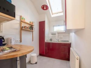 uma cozinha com uma porta vermelha e um lavatório em Snug holiday home in Bergerac with terrace em Bergerac