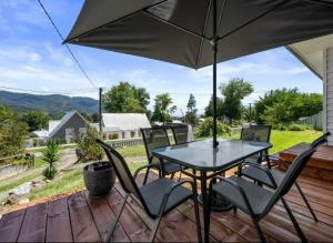 un tavolo e sedie su una terrazza con ombrellone di Mount Beauty 3BR Home a Mount Beauty
