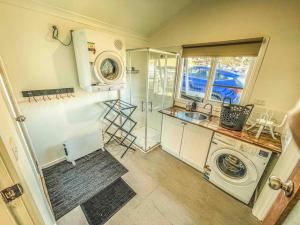 un piccolo bagno con lavatrice e lavandino di Mount Beauty 3BR Home a Mount Beauty Altre 11 foto
