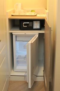 een open koelkast met een magnetron erop bij MIGDAL Luxury Suites Roma Testaccio in Rome