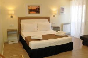 een slaapkamer met een groot bed en 2 handdoeken bij MIGDAL Luxury Suites Roma Testaccio in Rome
