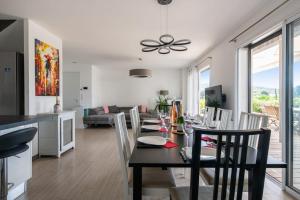 jadalnia i salon ze stołem i krzesłami w obiekcie Maison Janas - Welkeys w mieście La Seyne-sur-Mer