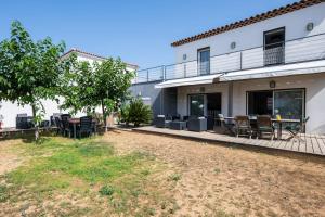 patio z krzesłami i stołami przed budynkiem w obiekcie Maison Janas - Welkeys w mieście La Seyne-sur-Mer +15 zdjęć