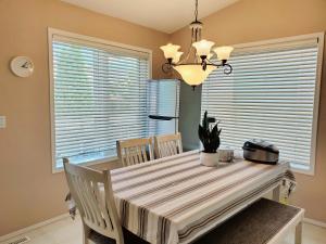 a dining room with a table and chairs and a chandelier at Saskatoon Lashyn Cove Homestay in Saskatoon