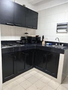 uma cozinha com armários pretos e um lavatório em Centro las Bovedas A2-31 apartamento em Cartagena das Índias
