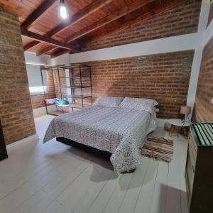 1 dormitorio con cama y pared de ladrillo en M&M Depto en Cipolletti