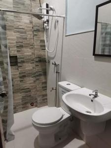 曼巴豪的住宿－RedDoorz at Gracia's Calzada Inn Camiguin，浴室配有卫生间、盥洗盆和淋浴。
