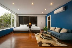 um quarto com 2 camas e uma parede azul em Hanoi 20 Hotel & Apartment em Hanói