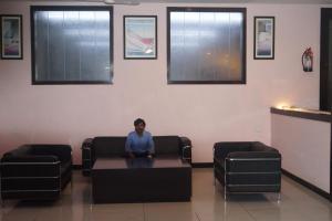 Rudrapur的住宿－CENTER POINT，坐在等候室桌子上的男孩