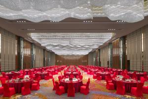 a large banquet hall with red tables and chairs at Wanda Vista Dongguan - Free Canton Fair shuttle bus during Canton Fair period in Dongguan +42 photos