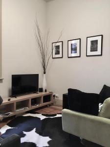 ein Wohnzimmer mit einem Flachbild-TV und einem Sofa in der Unterkunft escape@flinders Lane Melbourne CBD in Melbourne