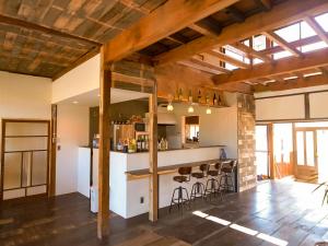 una cocina con barra y taburetes en una casa en Guest House Inawashiro~Hanbog~ en Inawashiro