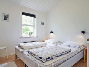 a large bed in a white room with a window at 6 person holiday home in Aakirkeby-By Traum in Vester Sømarken