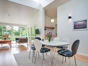 a dining room with a white table and chairs at Holiday home Aakirkeby XXXV in Vester Sømarken
