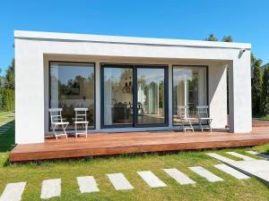 een huis met vier stoelen op een houten terras bij 6 person holiday home in Hornbæk-By Traum in Hornbæk